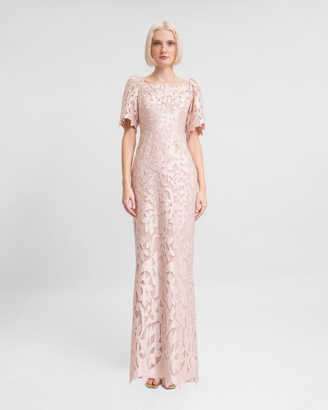 An embroidered satin long evening dress in blush color with puffed sleeves and a slit at the back.