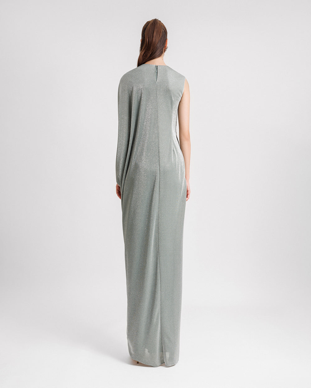 The back of an asymmetrical draped evening dress in shiny teal fabric.