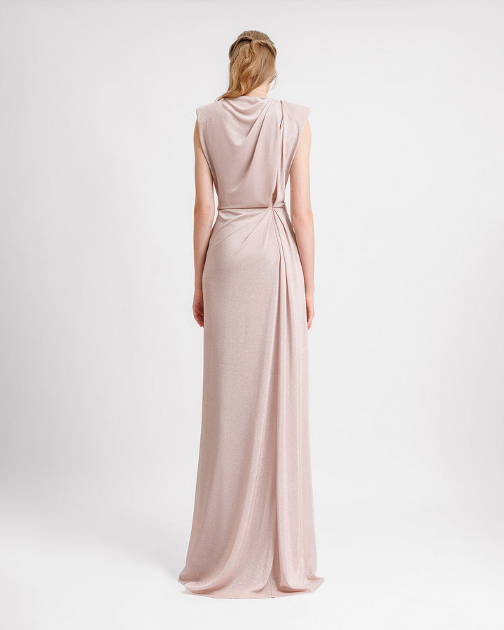 The back of an evening dress in blush color with draping at the waist and back.