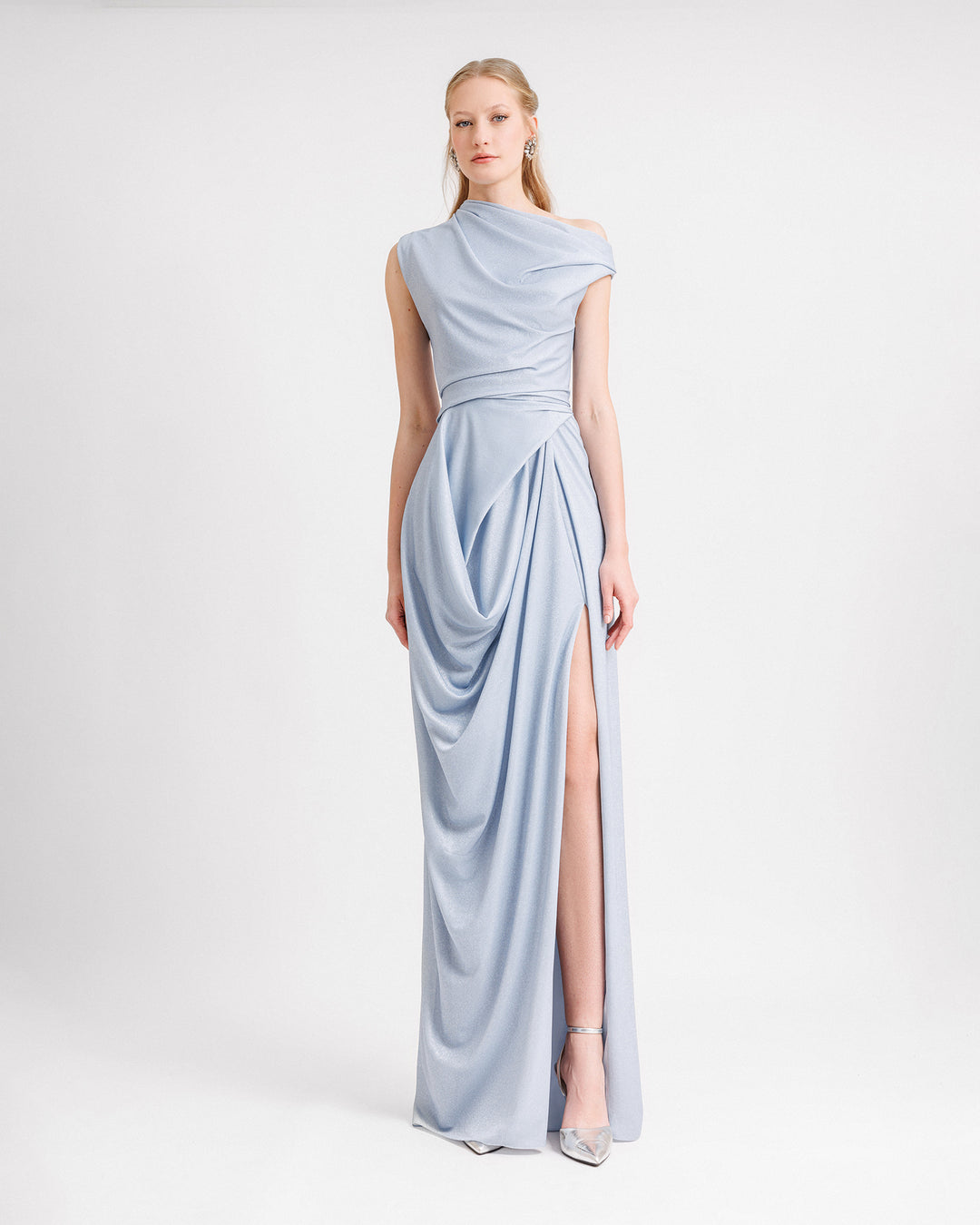 A light blue draped evening dress featuring an asymmetrical neckline and a slit on the side.