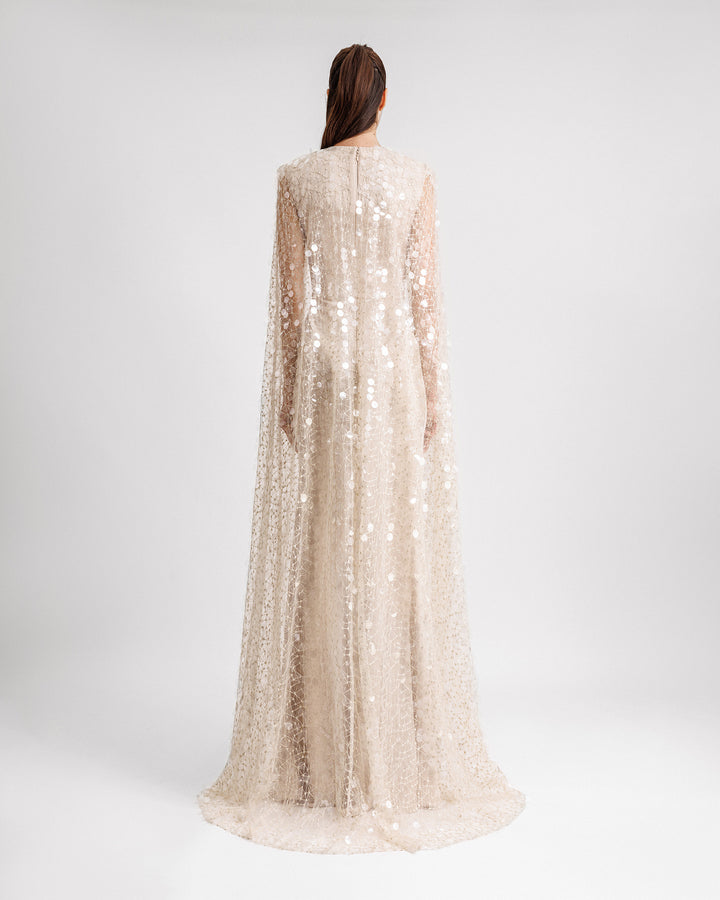 The back of a champagne satin evening dress with a fully sequins embroidered tulle cape.