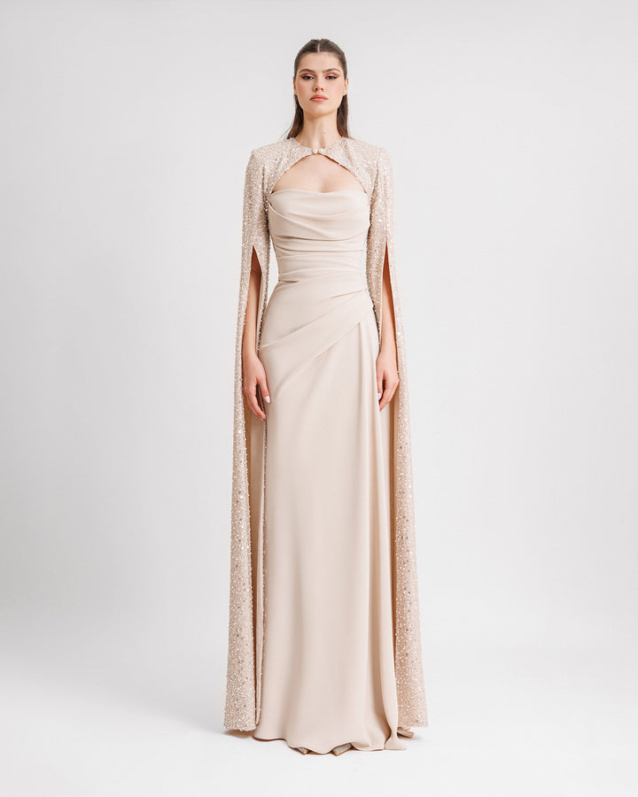 A strapless champagne draped dress with fully beaded floor length sleeves bolero.