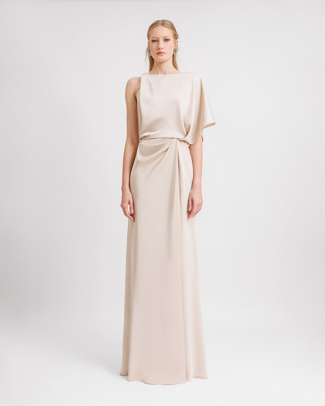 An asymmetrical neckline champagne dress with draping on the waist.