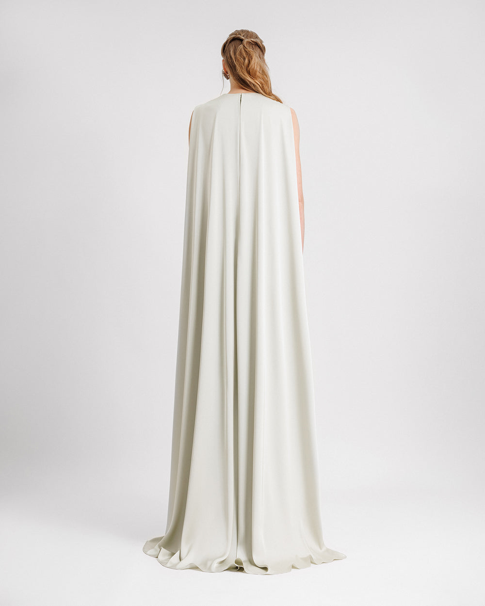 A light mint evening dress in satin fabric with a floor length cape-like back.