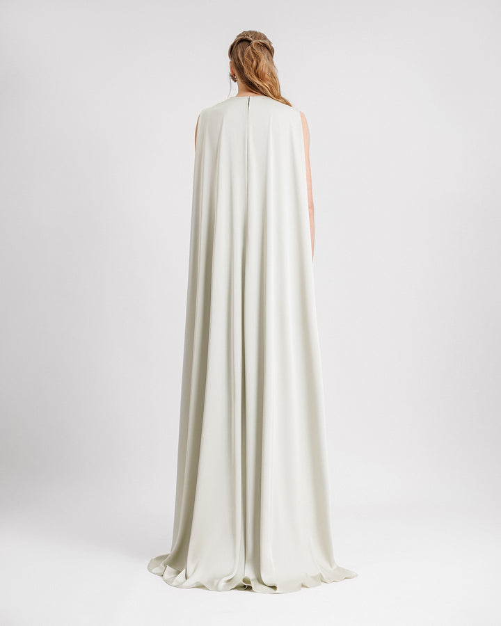 A light mint evening dress in satin fabric with a floor length cape-like back.