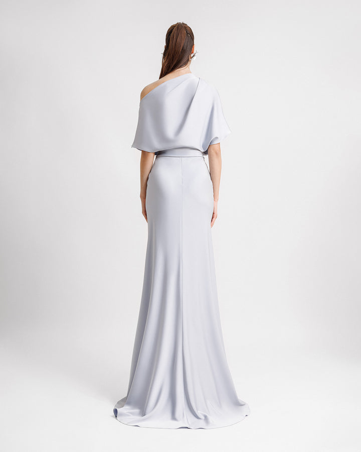 The back of an asymmetrical draped neckline evening dress in light blue satin fabric with an A-cut skirt.