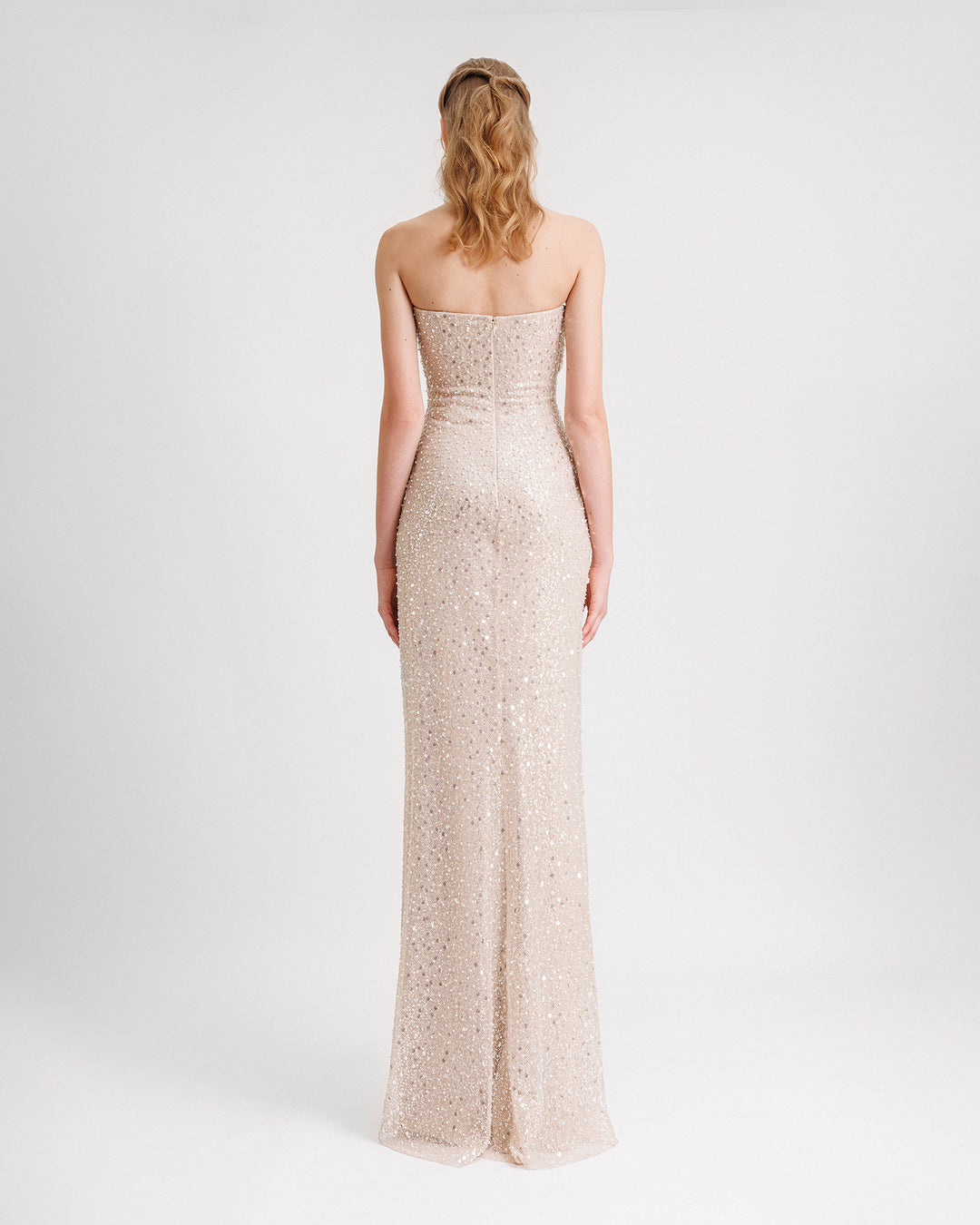 The back of a strapless draped evening dress in champagne beaded tulle.