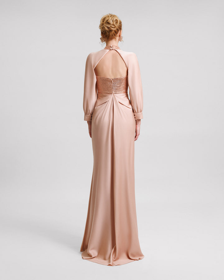 The back of a strapless evening dress with a stone embellished corset and draped skirt, paired with a detachable bolero featuring draped sleeves and an embellished collar.