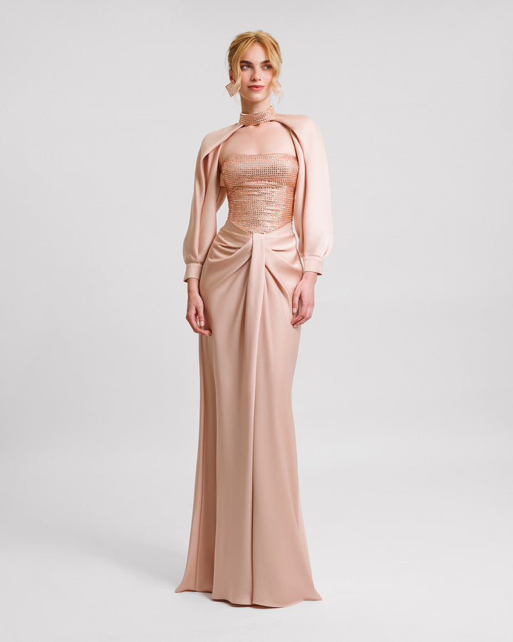 A strapless evening dress with a stone embellished corset and draped skirt, paired with a detachable bolero featuring draped sleeves and an embellished collar.