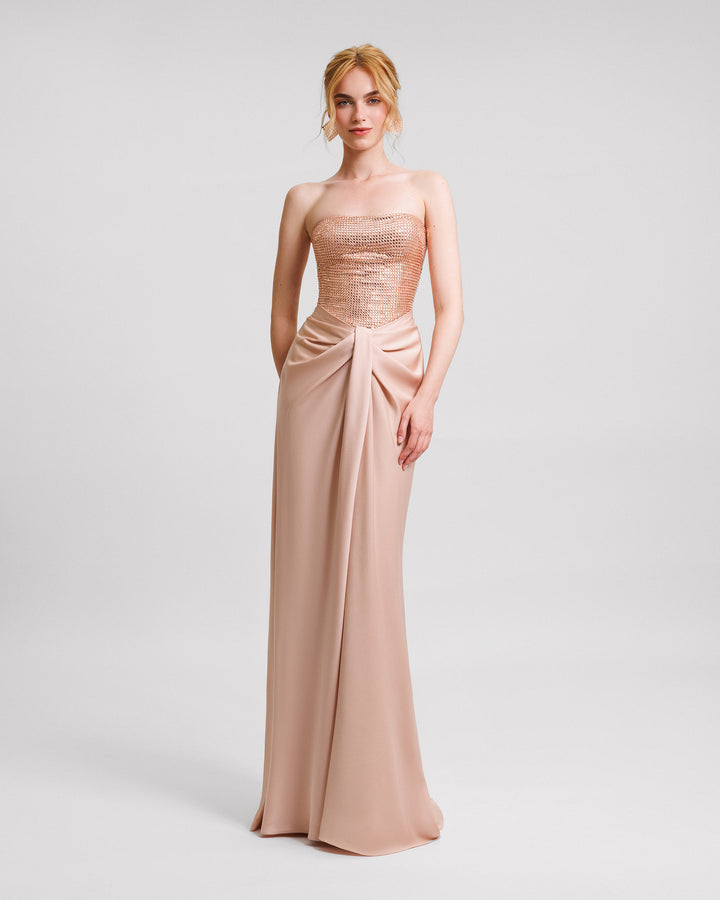 A strapless evening dress with a stone embellished corset and draped skirt.