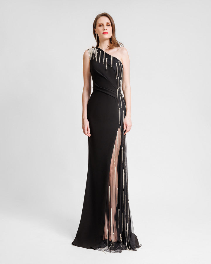 A one-shoulder slim-cut black dress with beaded tulle along the side and a see-through slit opening.