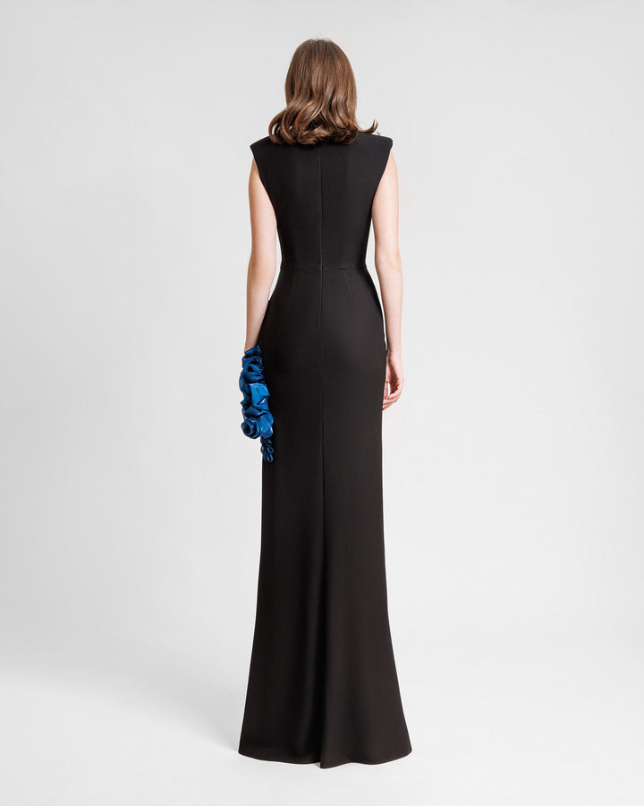 The back of a slim-cut black evening dress featuring petrol floral draping on the side.