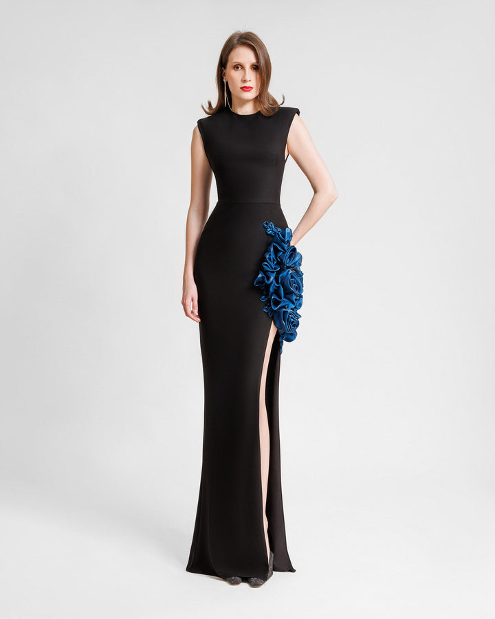 A slim-cut black evening dress featuring petrol floral draping and a slit on the side.