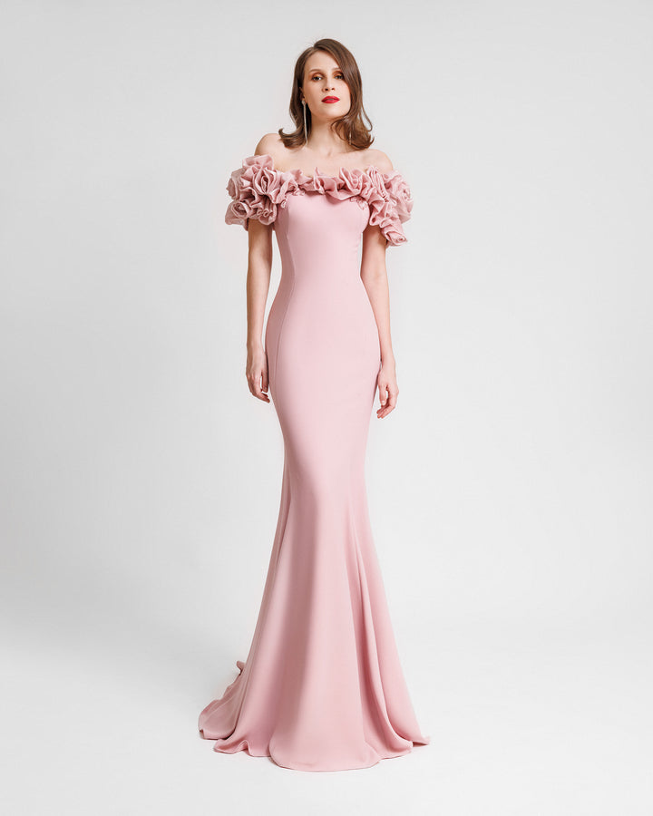 A slim-cut pink evening dress featuring off-the-shoulders floral draping.