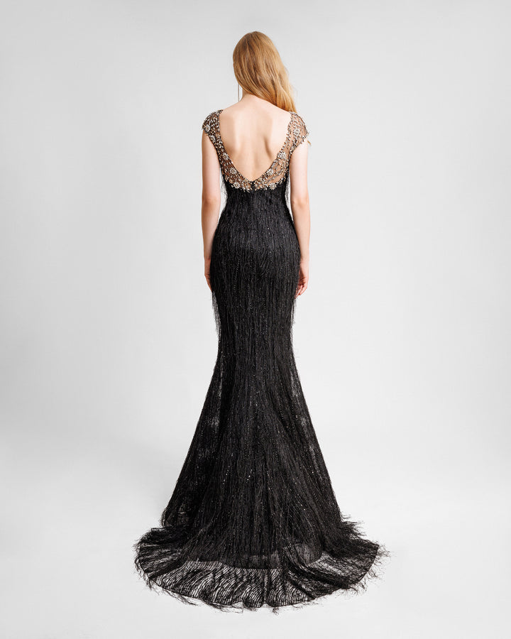 The back of a black fringes evening dress with a beaded neck and shoulders, and an open back.