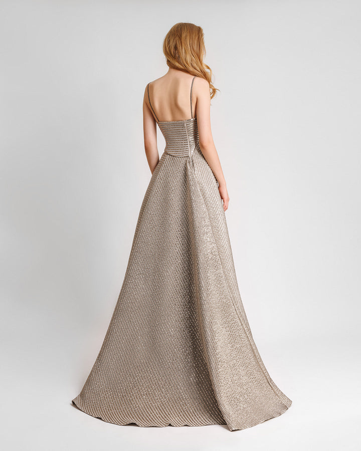 There back of a champagne evening dress featuring an asymmetrical waist cut and a full skirt.