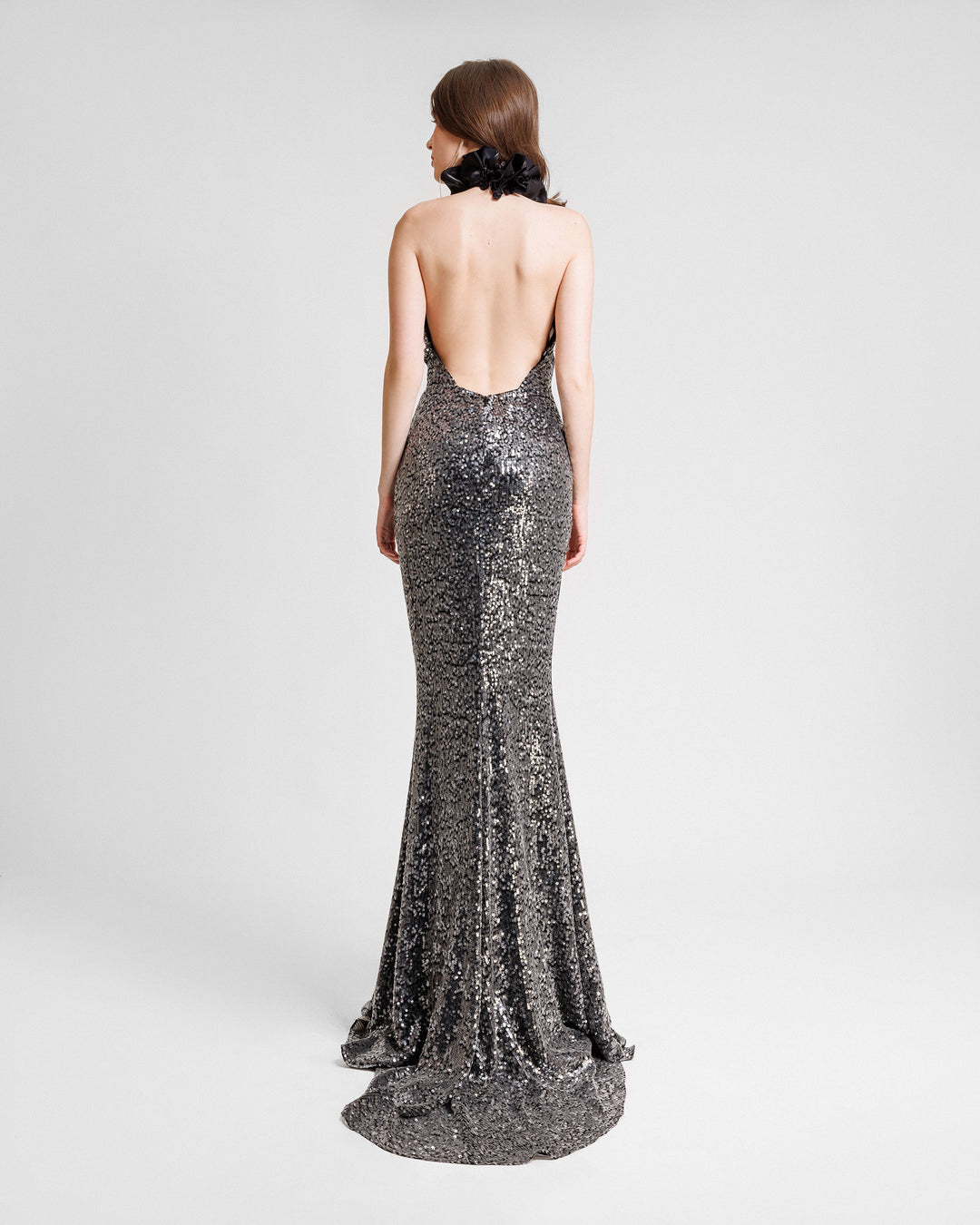 The back of a slim-cut embroidered sequins evening dress with floral draping on the neck and a low open back..