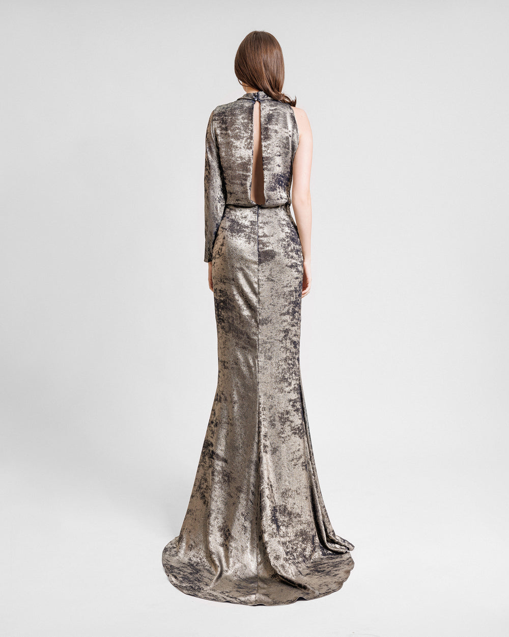 The back of a one sleeve evening dress featuring a long cut out on the back.