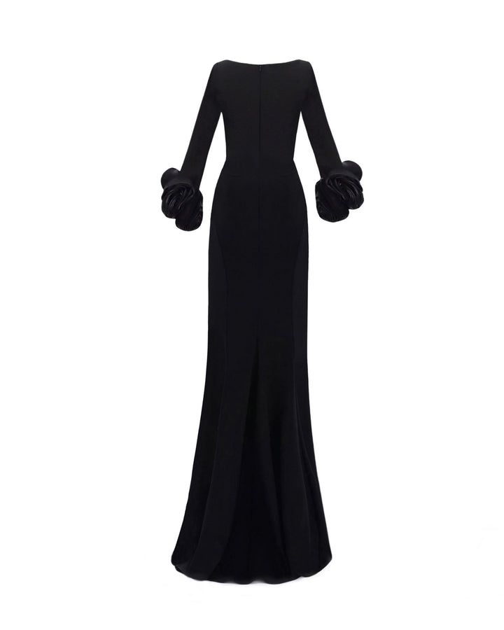 The back of a long sleeved black evening dress in crepe fabric featuring floral cuffs and a slim-cut skirt.