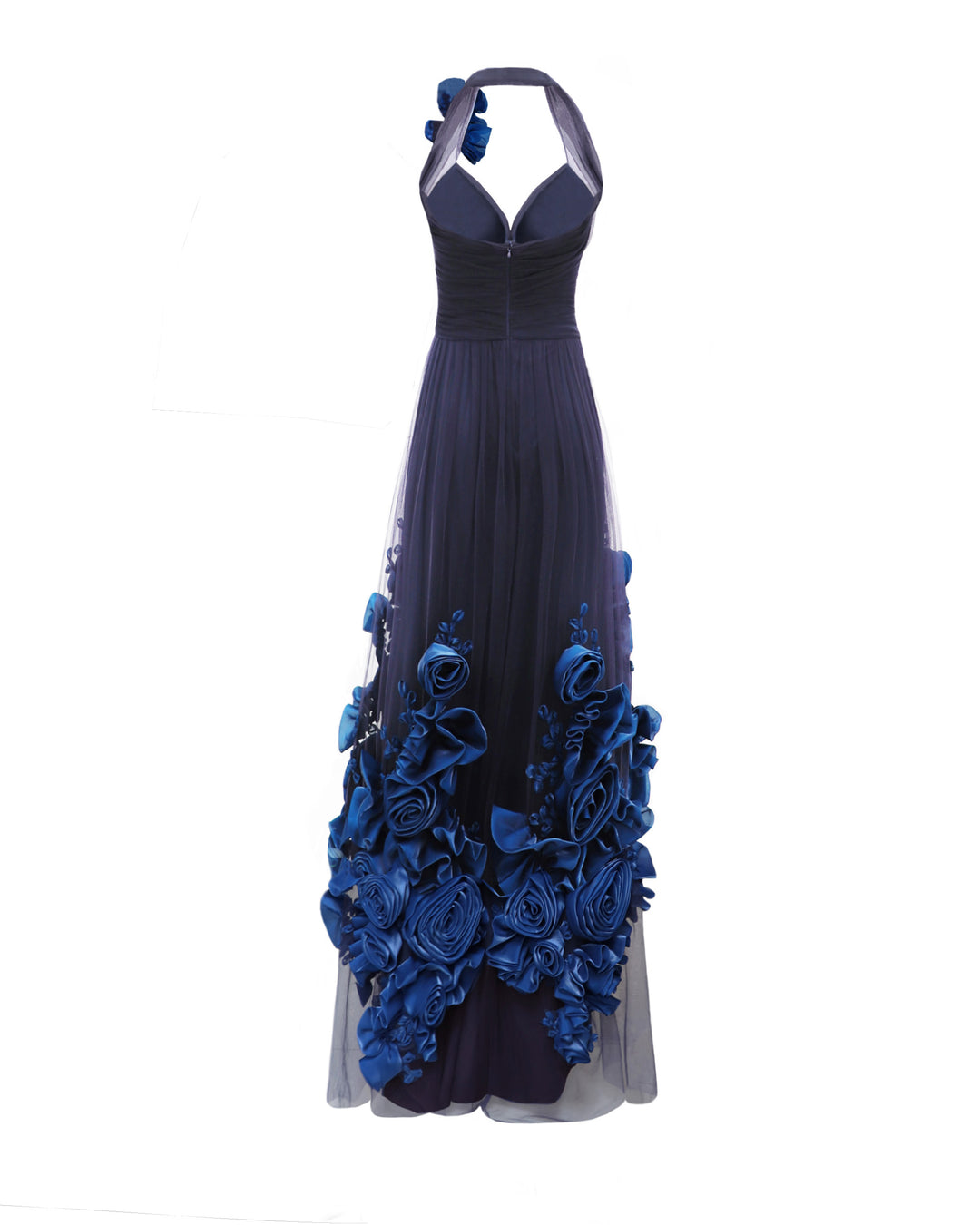 The back of a flared evening dress in navy draped tulle with an open back and a floral draping on the shoulder and hemline.