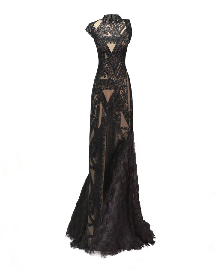 An asymmetrical mermaid cut evening dress in black patterned lace fabric with a single-side fringed hemline.