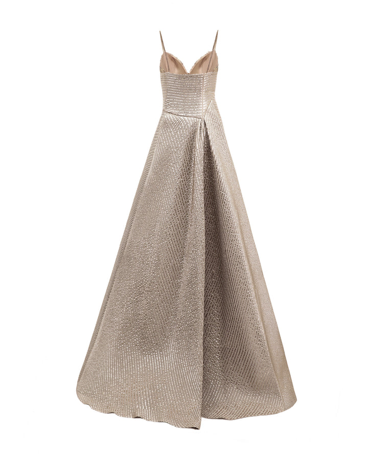 There back of a champagne evening dress featuring an asymmetrical waist cut and a full skirt.