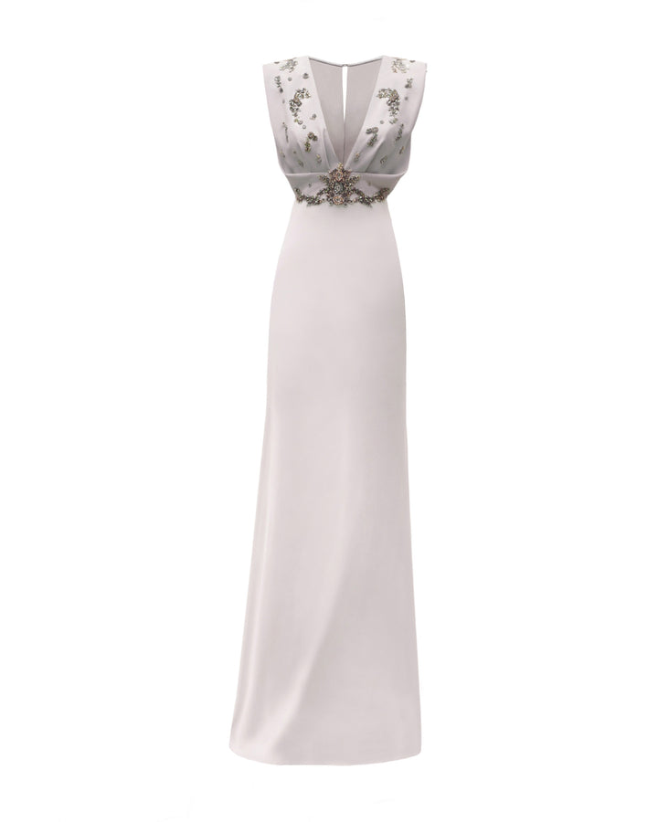 A deep v-neckline griege evening dress with a draped and beaded bodice.