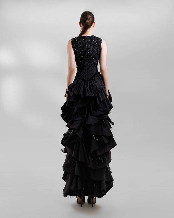 The back of a V-neckline black evening dress with beadings and ruffled taffeta layers.