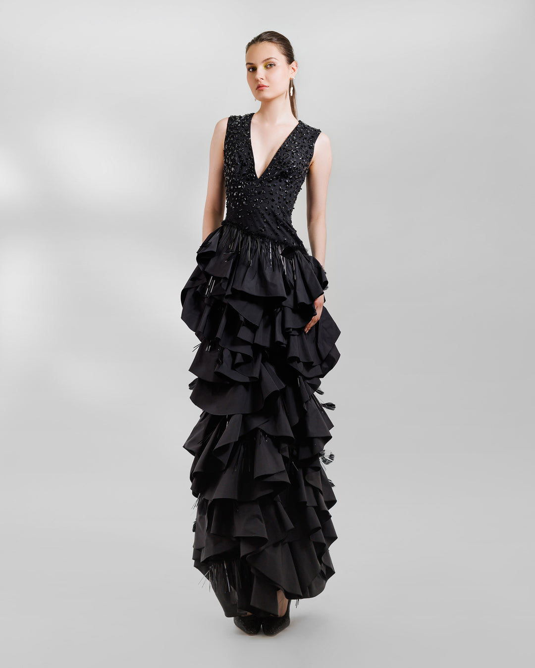 A V-neckline black evening dress with beadings and ruffled taffeta layers.