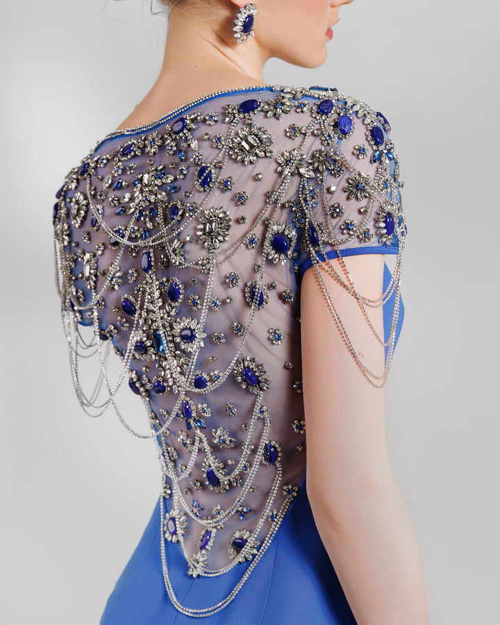 A close-up of the short full beaded see-through sleeves and a full open back with see-through tulle beadings and chains.