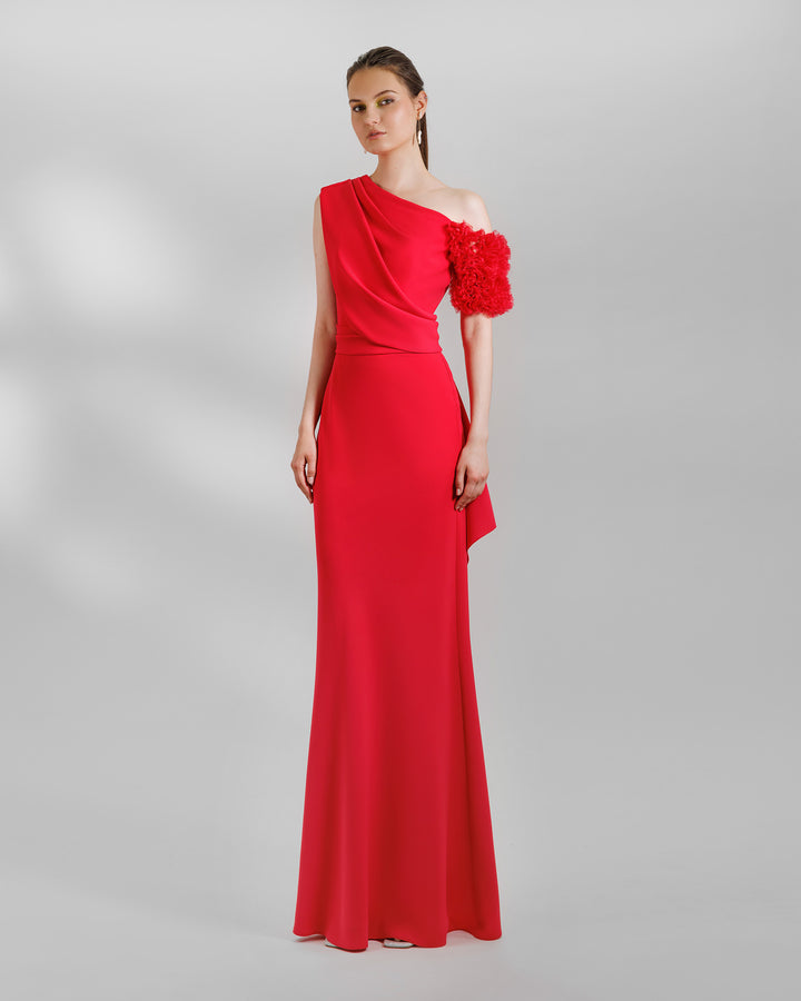 A One-shoulder red evening dress with a rushed organza short sleeve, draped open back, and a ruffled slit.