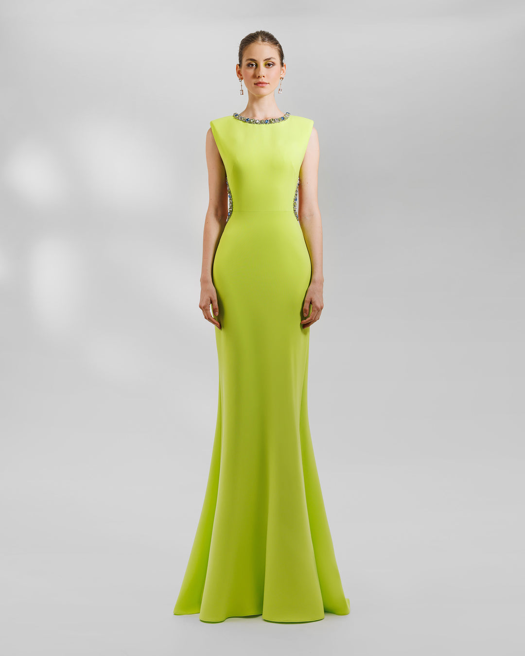 A slim-cut padded shoulders lime long evening dress, featuring beadings on the neckline and the open back.