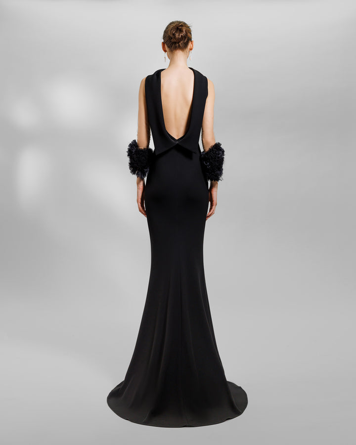 The back of a halter-neck slim-cut black evening dress with a reversed collar, open back, and rushed organza details on the sleeves.