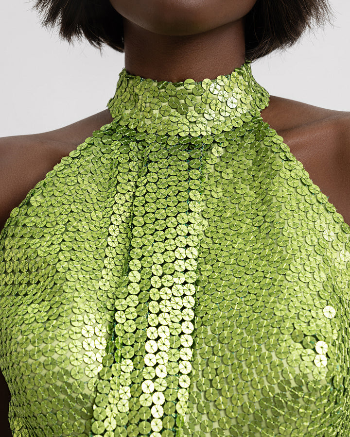 A close-up of a halter neckline full sequins evening dress in green.