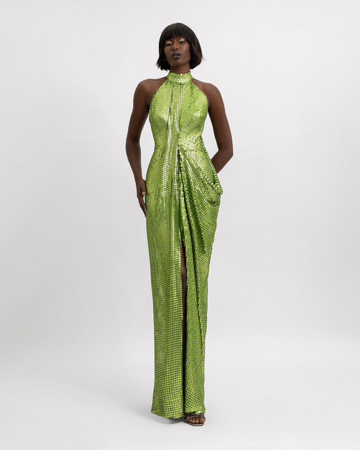 A halter neckline full sequins evening dress in green with draping details and a slit at the front.