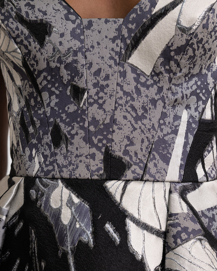 A close-up a printed jacquard devoré in black, grey hues, and champagne color. 