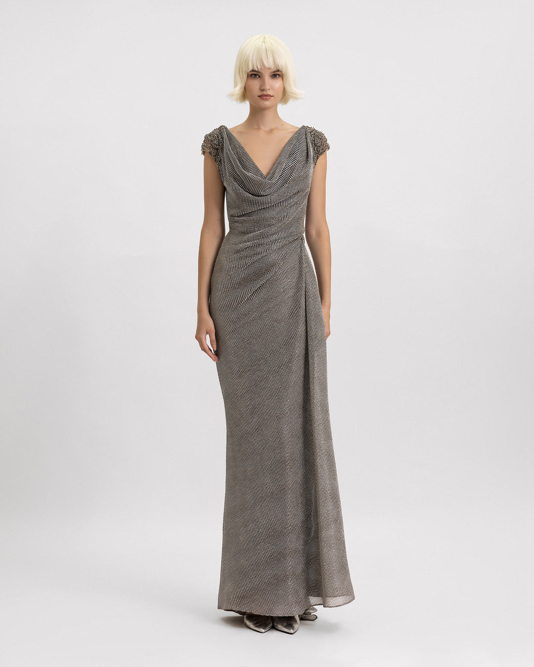 A draped cowl-neckline evening dress featuring beadings on the shoulders and a draped waist in grey metallic jersey.