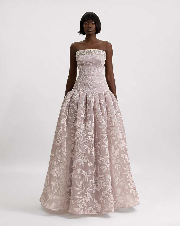 A beaded strapless evening dress with a dropped-down waistline and a draped skirt.