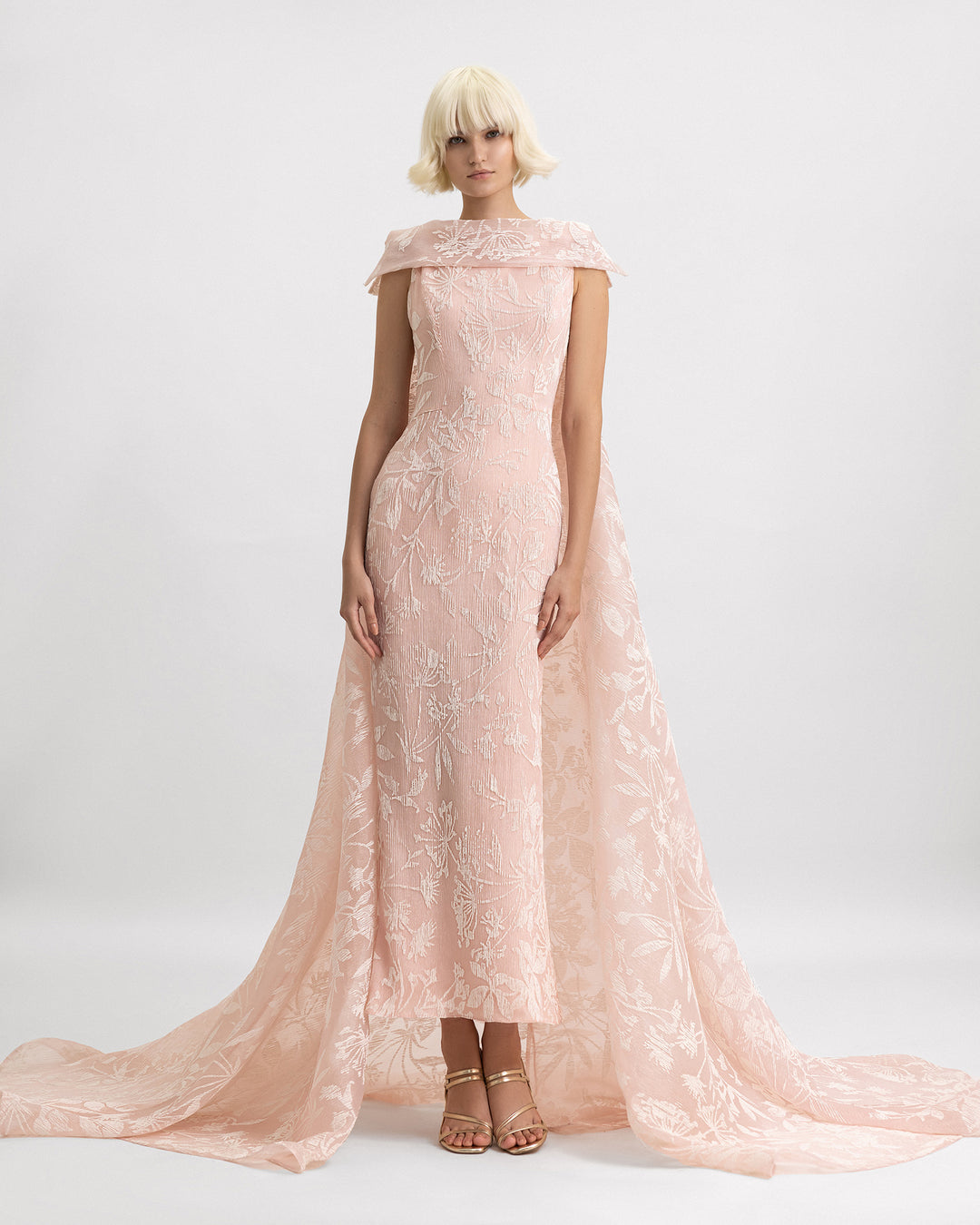 A slim-cut evening dress in light pink pleated organza Jacquard featuring a reversed collar and a long cape.