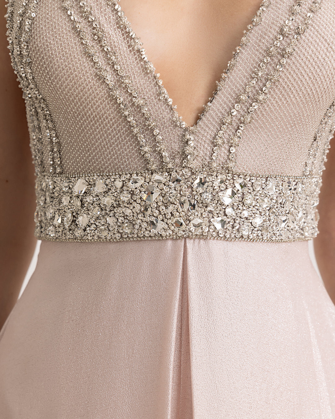 A close-up of a beaded V-neckline jumpsuit in light pink.