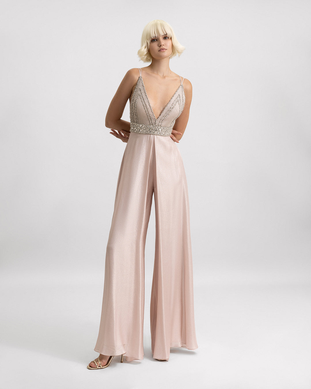 A beaded V-neckline jumpsuit in light pink with flared pants.