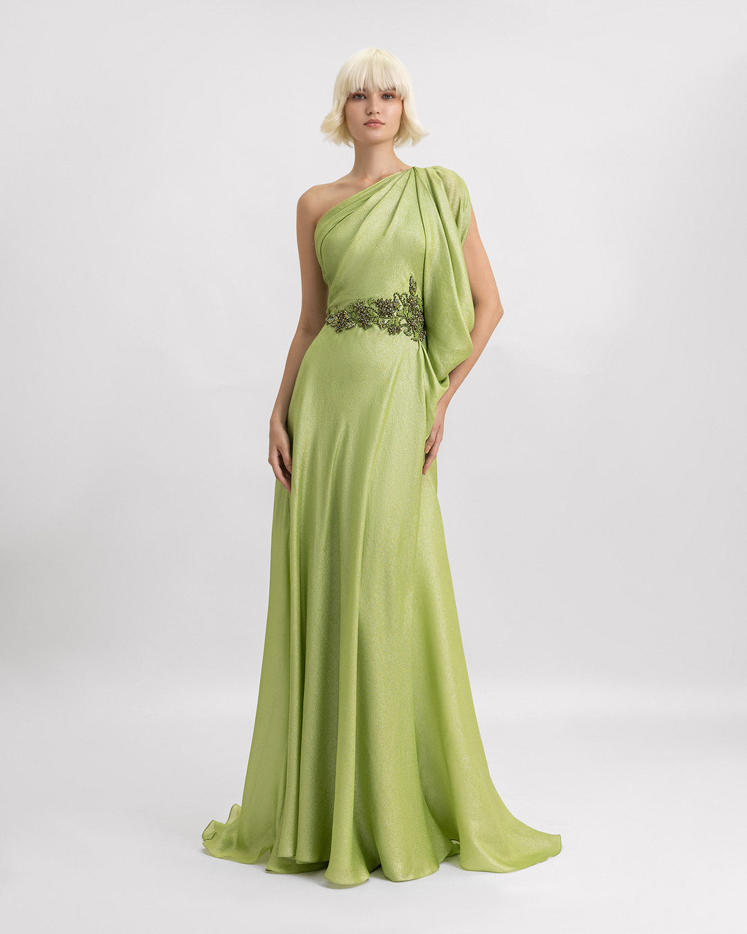 A one-shoulder green evening dress with draping details and beadings on the waistline.