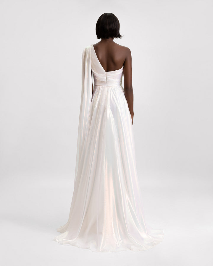 The back of a one-shoulder cape like sleeve evening dress in ivory chiffon irisé.