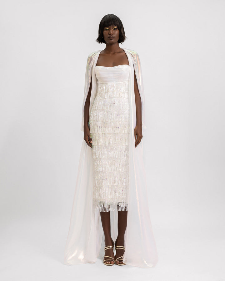 A sequins tasseled ivory short dress featuring a chiffon irisé draped long cape with a slit at the back.