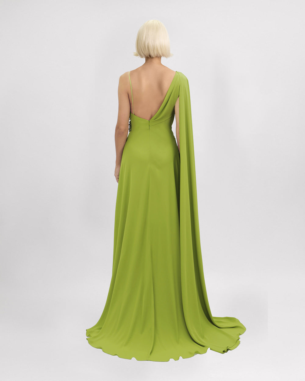 The back of an asymmetrical neckline evening dress with a cape-like sleeve and an open back.