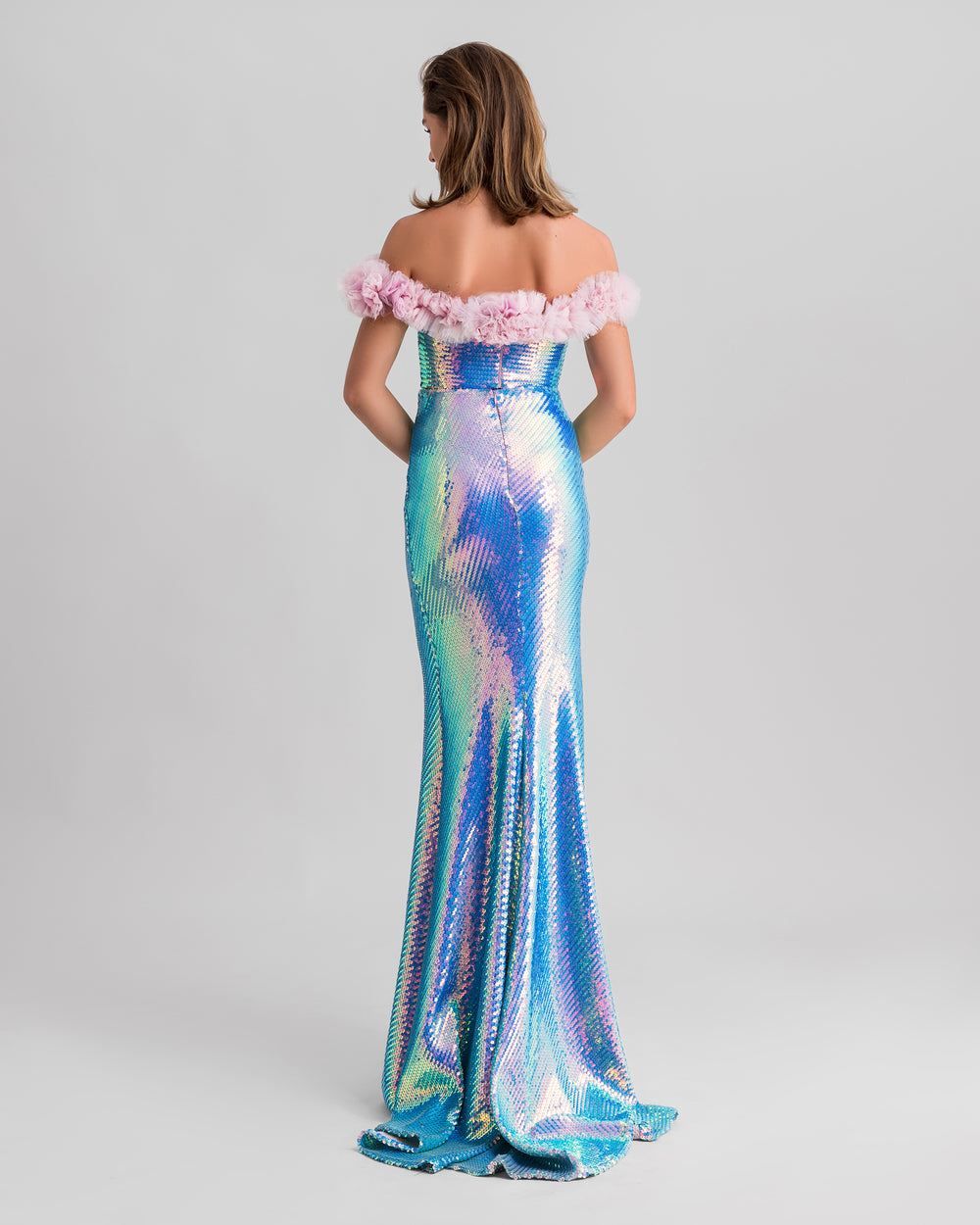 The back of a sequined slim-cut evening dress in aqua blue with a pink rushed tulle on the neckline.