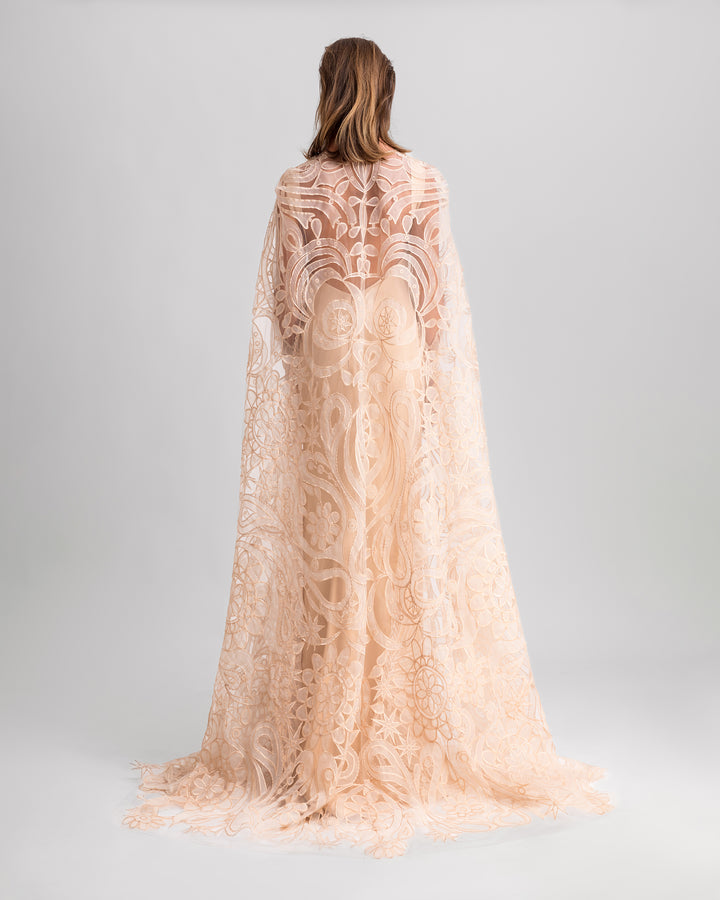 A low open back slim-cut beige, paired with a wide patterned lace cape.