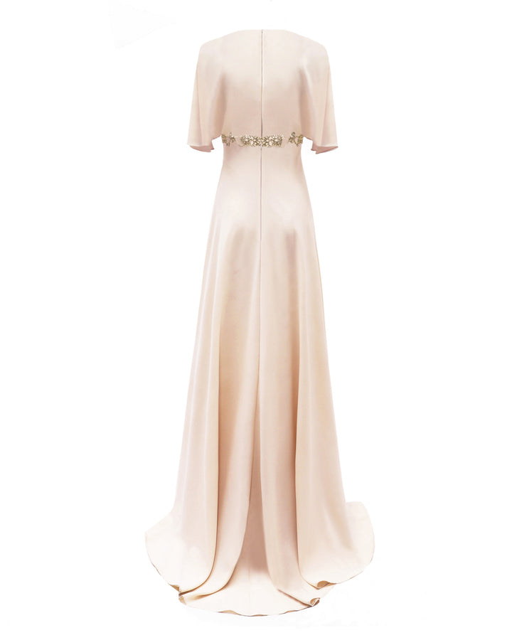 The back of a cream evening dress, featuring a beaded belt and flared sleeves.