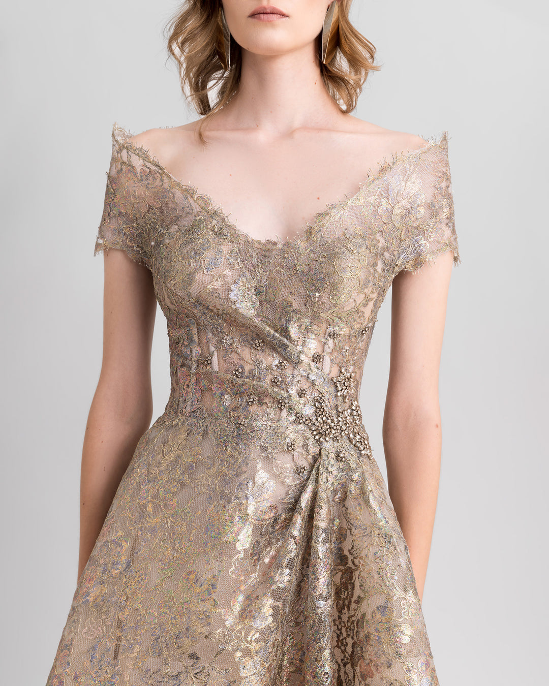 A close-up of an off-the-shoulders golden evening dress featuring beadings on the waist.