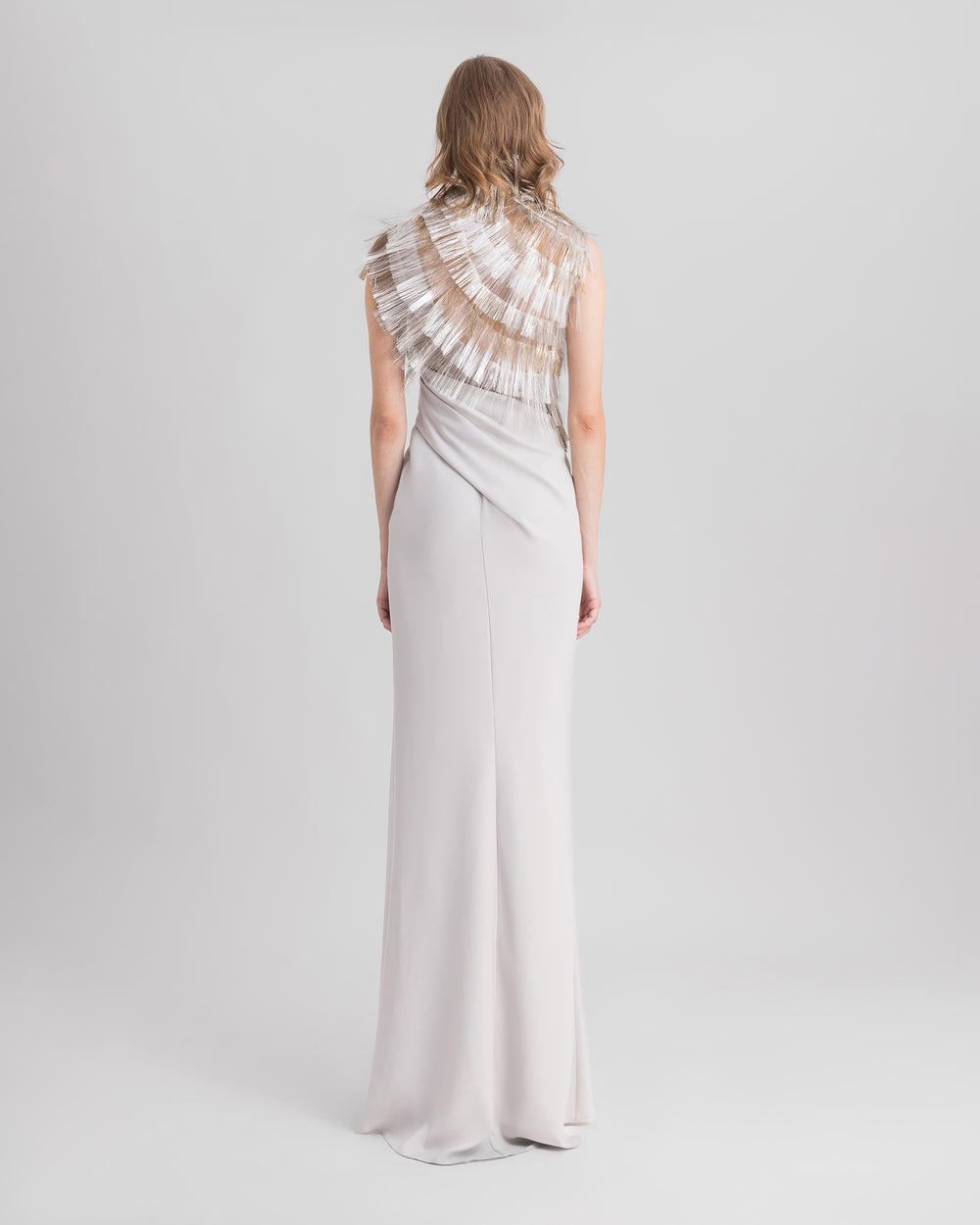 The back of an asymmetrical neckline grey evening dress featuring draping on the waist.